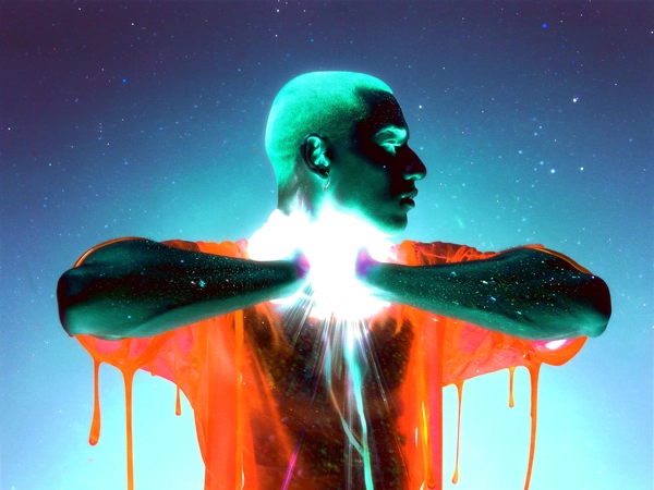 Electric teal veins pulse along the contours of a luminous male figure, his profile poised with elbows thrust forward like translucent wings, hands clasped behind a neck melting into iridescent vapor. His attire liquefies into dripping latex streams, radiant orange threads bleeding into ghostly silk that vaporises mid-motion, dispersing into pastel staircases of light. The arctic cyan void behind him intensifies the plasma white rim light that fractures and flares, flipping RGB channels to an infrared dreamscape where flesh dissolves into spectral ribbons. Coarse clusters of film grain throb with dust specks scattered like cosmic static, edges shimmering with faint gate-weave wobble as after-image streaks trail the radial energy of suspended motion. The image has a slightly blurry and low-resolution quality, resembling a video still or casual recording. Captured through a Canon EOS R5 paired with an RF 85 mm ƒ/1.2, layered with scanned 800 ISO tungsten film grain and sprocket-flash bloom—surreal inverted-color fashion editorial, heavy film grain texture